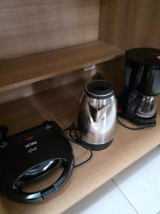 クリチバにあるApto lindo sacada com churrasqueiraのトースター、棚にコーヒーメーカー
