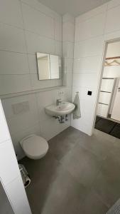 a white bathroom with a toilet and a sink at Boardinghouse Living in Gemmingen +56 photos