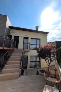 a house with a wooden deck with a staircase at Las Terrazas de Candás in Candás