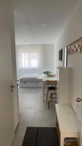 a white room with a bed and a table at Boardinghouse Living in Gemmingen +56 photos