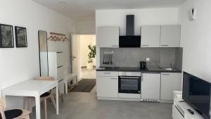 a kitchen with white cabinets and a white table and a tableablish at Boardinghouse Living in Gemmingen