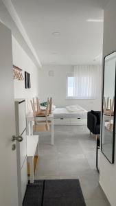 a white living room with a table and chairs at Boardinghouse Living in Gemmingen