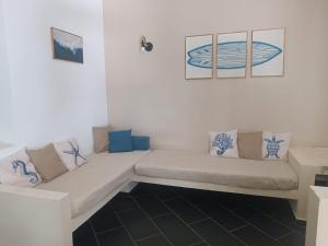a white couch in a white room with blue pillows at Casa Papaya19 in Sal Rei