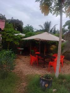 乌昆达Hideout studios的院子里伞下的桌子和椅子