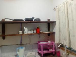 乌昆达Hideout studios的厨房里有一个架子,上面有锅碗瓢盆