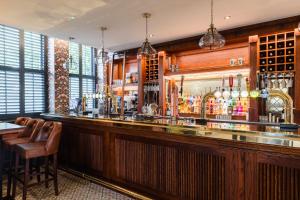 a bar in a restaurant with a counter and chairs at Pencelli Hotel in Treorky