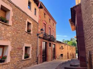 un callejón en un antiguo edificio de piedra con flores en las ventanas en El Racó de Baix, en Seva