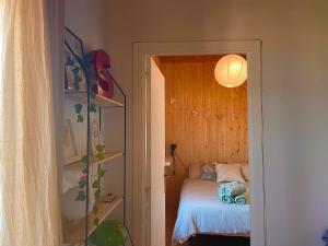 Un dormitorio pequeño con una cama y un estante con una lámpara. en El Racó de Baix, en Seva