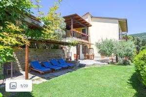 a house with blue chairs in a yard at VillAmato Casa Vacanze ULIVO in Arezzo