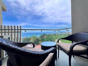 a balcony with chairs and a table and a view of the ocean at Room in Maribago in Lapu Lapu City