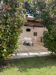 a patio with a table and chairs in a yard at Casa Carmucha in Villanueva de Arosa