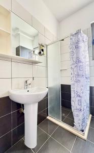 a bathroom with a sink and a shower curtain at Ama Saranda Apartment in Sarandë