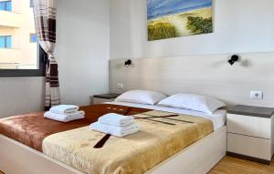 a bedroom with a bed with towels on it at Ama Saranda Apartment in Sarandë