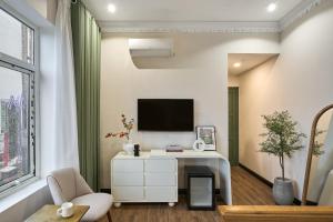 a living room with a white desk and a tv at The Passion Lux Airport Hotel Apartment in Ho Chi Minh City