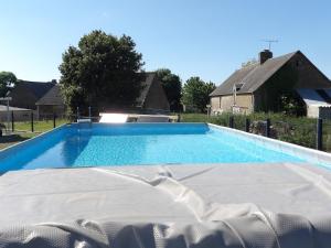 a large swimming pool with blue water in a yard at Chalet du Chesnot , Aucey-la-Plaine in Aucey-la-Plaine