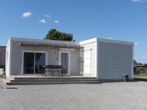 a small white building with a table in front of it at Chalet du Chesnot , Aucey-la-Plaine in Aucey-la-Plaine