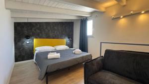 a bedroom with a bed with a chair and a couch at Casarkeb in Terrasini