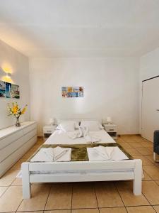 a white bedroom with a large bed in a room at Apartments Antonio in Pag