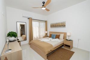 Un dormitorio con una cama y un ventilador de techo. en Modern 2BR Oasis Near Bayahibe Beach, en San Rafael del Yuma