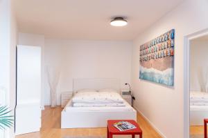 a white bedroom with a bed and a table at CityFlair in Rostock