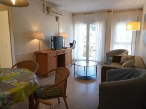 ein Wohnzimmer mit Sofa und Fernseher in der Unterkunft Grecia - L'Estartit, Centro - ES-323-88 in Torroella de Montgrí
