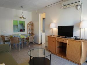 ein Wohnzimmer mit Flachbildfernseher und Tisch in der Unterkunft Grecia - L'Estartit, Centro - ES-323-88 in Torroella de Montgrí