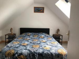 a bedroom with a bed with a blue and yellow comforter at Ty Amani - Breton Family Getaway in Plourivo