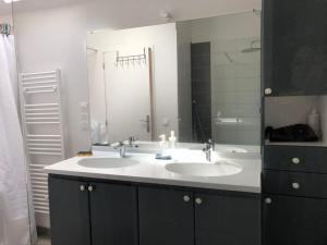 a bathroom with two sinks and a large mirror at Ty Amani - Breton Family Getaway in Plourivo