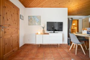 a living room with a television and a table at Blumenhaus mit Terrasse in Waren