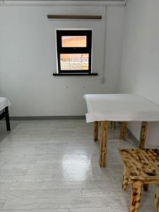 a white room with a table and a window at Altygat Lodge Barskoon in Barskoon +49 photos