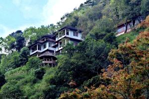 a house on the side of a hill at Blackberry Hills Munnar- Nature Resort & Spa in Munnar
