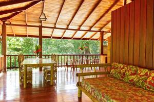 ein Wohnzimmer mit einem Sofa und einem Tisch auf einer Veranda in der Unterkunft Pieza Paraíso in Cabo Matapalo + 14 Fotos