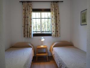 two twin beds in a room with a window at Casa a Solric con piscina compartida, 3 habitaciones, cerca de L'Estartit y playas - ES-323-40 in L'Estartit +26 photos