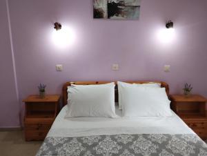 a bedroom with a bed with two lights on the wall at Nikos Apartments 3 in Kavos