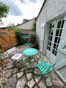 een patio met 2 stoelen en een tafel en een tafel bij Maison cosy avec jardin & parking, proche Disney in Chelles +2 foto's