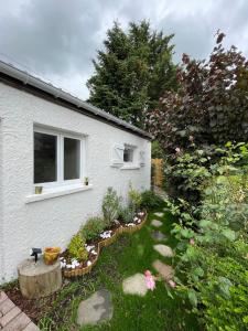 een wit huis met een tuin ervoor bij Maison cosy avec jardin & parking, proche Disney in Chelles