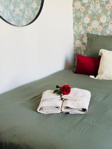 a bed with a towel and a rose on it at Le Velvet - Rennes in Rennes +11 photos