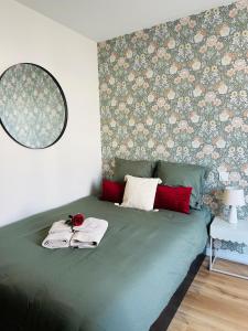 a bedroom with a green bed with a floral wallpaper at Le Velvet - Rennes in Rennes