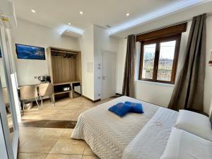 a bedroom with a bed and a desk and a window at La Maison Du Soleil Rooms in Agerola