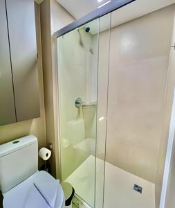 a bathroom with a toilet and a glass shower at O fenômeno, Apto nobre in Curitiba +32 photos