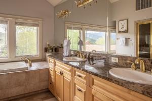a bathroom with two sinks and a large mirror at Crail Creek 85 in Big Sky +38 photos