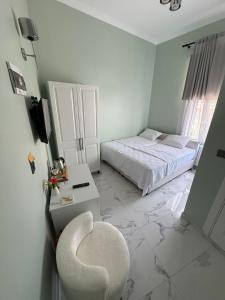 a white bedroom with a chair and a bed at Ada Meydan 76 in Adalar