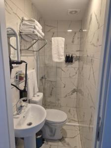 a white bathroom with a toilet and a sink at Ada Meydan 76 in Adalar
