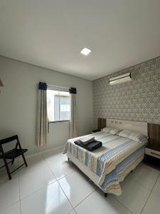 a bedroom with a large bed and a window at Apartamentos novos em condomínio no Caçari in Boa Vista