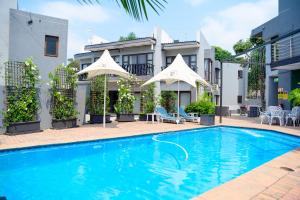 a swimming pool in front of a building at Khayalami Hotel - Mbombela in Nelspruit
