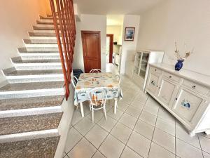 a dining room with a table and a staircase at Casa Marmolada - San Teodoro in San Teodoro