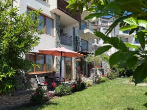 una casa con un paraguas en el patio en Sea Garden Escape - Byala, en Byala