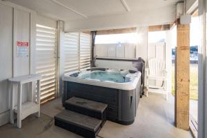a jacuzzi tub in a room with a window at New Build with Rooftop Deck & Panoramic Ocean Views in Kill Devil Hills