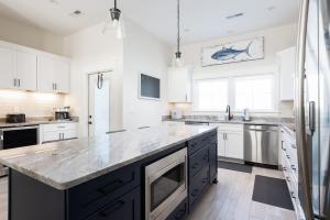 a kitchen with white cabinets and a large counter top at New Build with Rooftop Deck & Panoramic Ocean Views in Kill Devil Hills