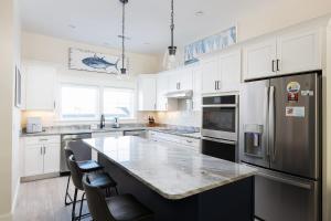 a kitchen with white cabinets and a large counter top at New Build with Rooftop Deck & Panoramic Ocean Views in Kill Devil Hills